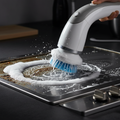 Electric cleaning brush scrubbing greasy kitchen stovetop